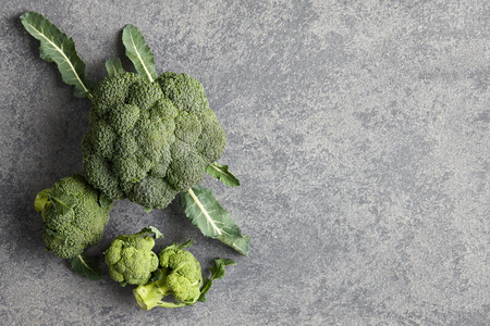 Fresh broccoli with leaves on gray stone backgroundの写真素材