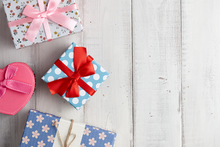 Bright christmas gift boxes with different patterns on white wooden backgroundの写真素材