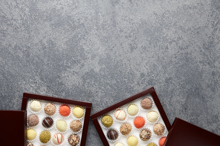 Various chocolate truffle candies in a box on gray stone backgroundの写真素材