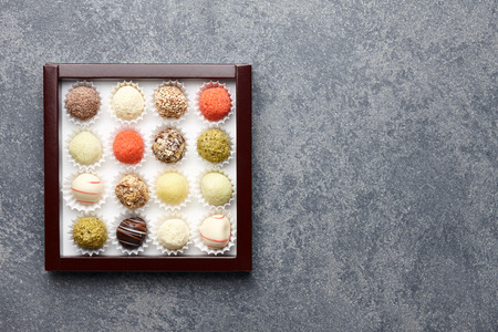 Various chocolate truffle candies in a box on gray stone backgroundの写真素材