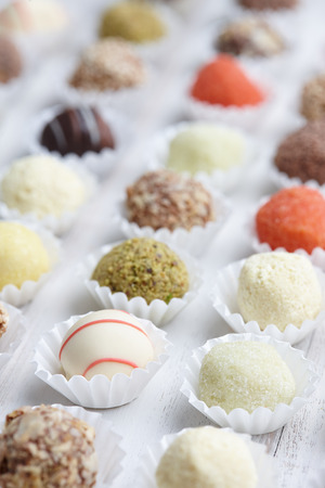 Chocolate truffle candies on white wooden backgroundの写真素材