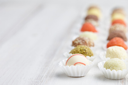 Chocolate truffle candies on white wooden backgroundの写真素材