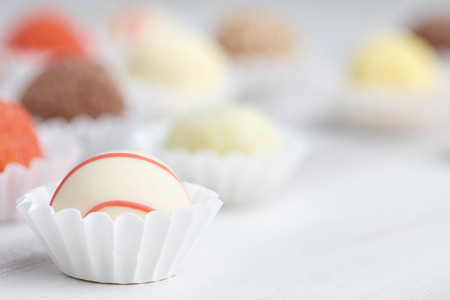 Chocolate truffle candies on white wooden backgroundの写真素材