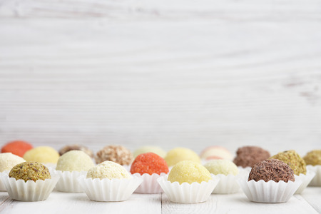 Chocolate truffle candies on white wooden backgroundの写真素材