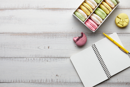 Box of colorful macarons and notebookの写真素材