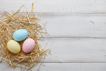 Colorful Easter eggs on white wooden backgroundの写真素材