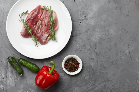 Raw duck breast in white plate with vegetablesの写真素材