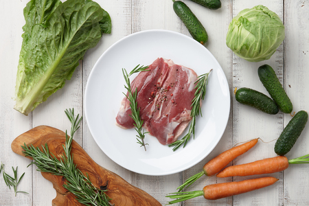 Raw duck breast in white plate and vegetablesの写真素材