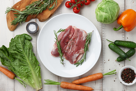 Raw duck breast in white plate and vegetablesの写真素材