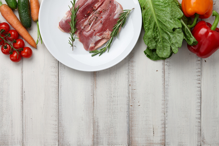 Raw duck breast in white plate and vegetablesの写真素材