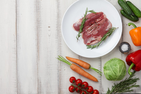 Raw duck breast in white plate and vegetablesの写真素材