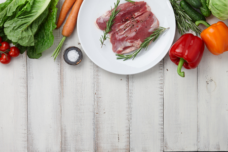 Raw duck breast in white plate and vegetablesの写真素材