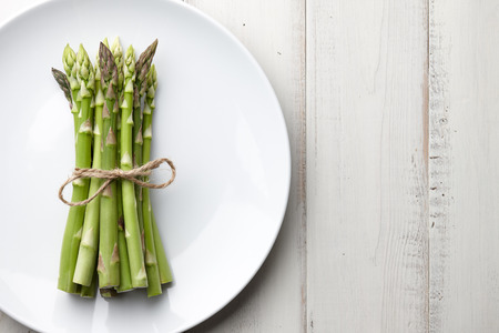 Bunch of fresh asparagus on wooden tableの写真素材