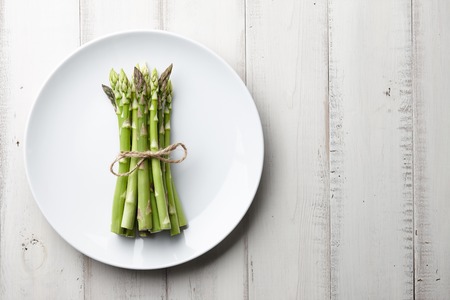 Bunch of fresh asparagus on wooden tableの写真素材