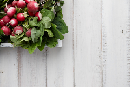 Fresh radish in wooden box on white table, top viewの写真素材