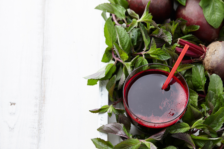 Fresh beetroot juice with herbs in white wooden tray, copy spaceの写真素材