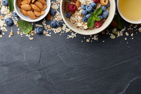 Healthy cereal breakfast with seasonal berries, almonds, farm milk and honeyの写真素材