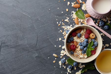 Healthy cereal breakfast with seasonal berries, almonds, farm milk and honeyの写真素材