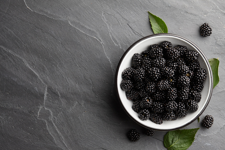 Bowl of fresh ripe blackberries on textured stone backgroundの写真素材