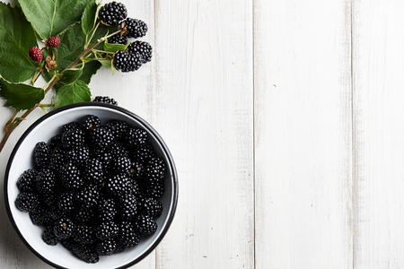 Bowl of fresh ripe blackberries on textured stone backgroundの写真素材