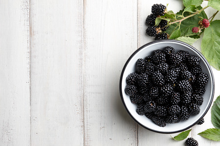 Bowl of fresh ripe blackberries on textured stone backgroundの写真素材