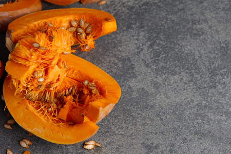 Halloween pumpkin slices with seeds on gray textured stone backgroundの写真素材