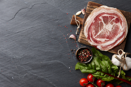 Traditional Spanish smoked serrano ham or jamon on stone textured background, top viewの写真素材