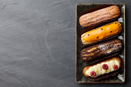 Plate with french eclairs on stone backgroundの写真素材