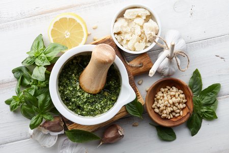 Basil pesto sauce with main ingredients: fresh basil leaves, parmesan cheese, pine nuts, garlic and lemonの写真素材