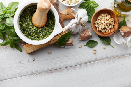 Basil pesto sauce with main ingredients: fresh basil leaves, parmesan cheese, pine nuts, garlic and lemonの写真素材