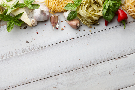 Raw homemade italian pasta and ingredients on white wooden background, cooking processの写真素材