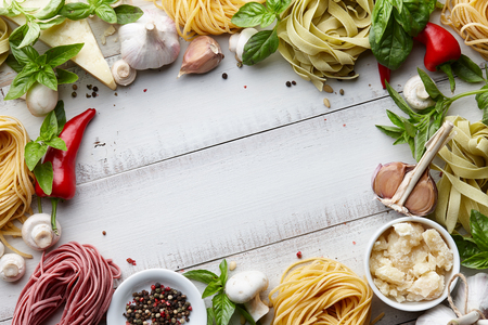 Raw homemade italian pasta and ingredients on white wooden background, cooking processの写真素材