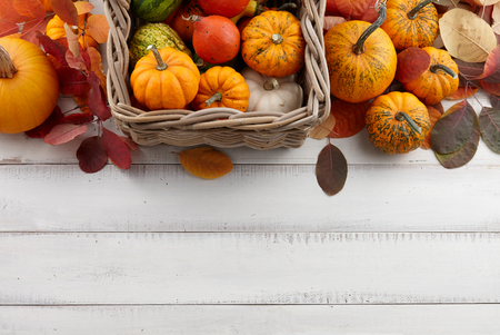 Wicker basket with colorful pumpkins and gourds for Halloween and Thanksgiving, holiday decorationの写真素材