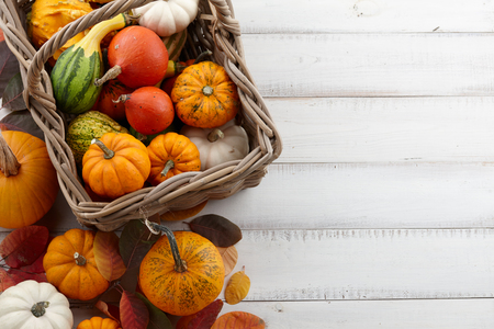 Wicker basket with colorful pumpkins and gourds for Halloween and Thanksgiving, holiday decorationの写真素材