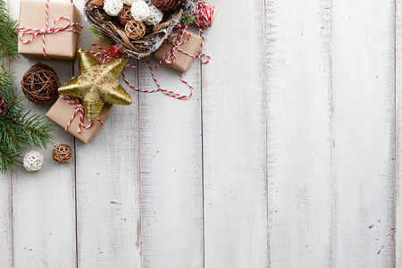 Christmas toys, decorations, presents and gift boxes wrapped in kraft paper on white wooden background, copy spaceの写真素材