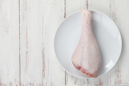 Turkey drumstick with skin in big plate isolated on white backgroundの写真素材