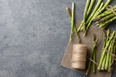 Bunch of fresh green asparagus on dark wooden background, top viewの写真素材