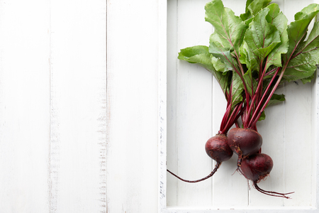 Fresh harvested beetroot in white wooden tray, top viewの写真素材