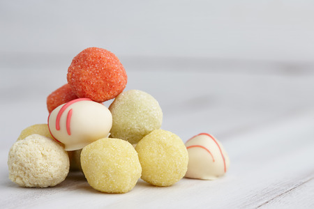 Assorted handmade truffle chocolates pyramid on white wooden table, copyspaceの写真素材