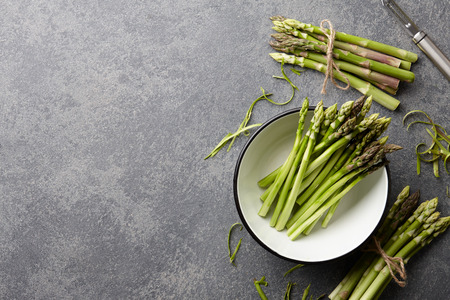 Peeling and cooking fresh raw asparagus on stone kitchen countertop, top viewの写真素材