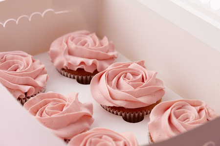 Muffins or cupcakes with flower shaped cream in box, close up viewの写真素材