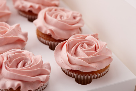 Muffins or cupcakes with flower shaped cream in box, close up viewの写真素材