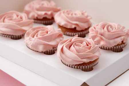 Muffins or cupcakes with flower shaped cream in box, close up viewの写真素材