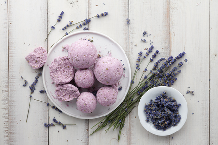 Natural cosmetics. Handmade lavender bath bombs and lavender flowers on white wooden planks, top viewの写真素材