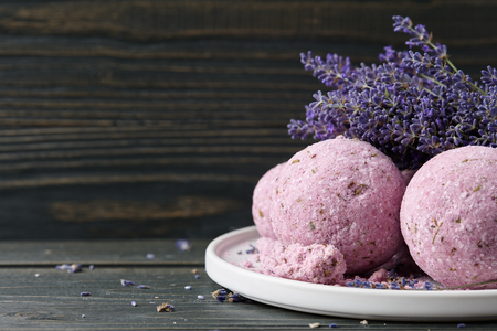 Lavender bath bombs and beautiful lavender flowers on dark wooden table. Natural skincare cosmeticsの写真素材
