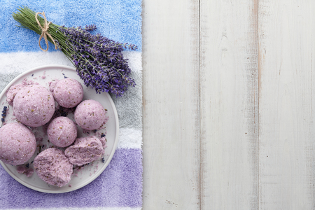 Natural cosmetics. Lavender bath bombs, flowers and towel on white wooden planks, top viewの写真素材