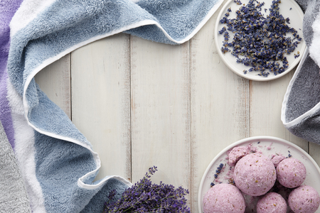 Handmade lavender bath bombs, lavender flowers and purple colored towel on white wooden planks, top viewの写真素材