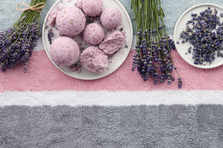 Handmade lavender bath bombs and lavender flowers on striped bath towel, top viewの写真素材