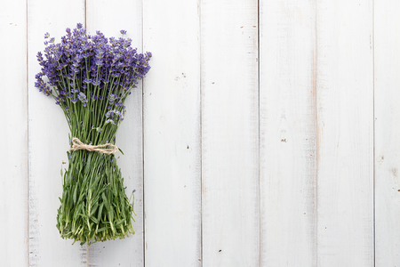 Beautiful lavender flowers bouquet on white wooden planks, top viewの写真素材