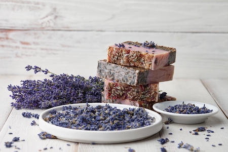 Lavender soap pile and flower blossoms on white wooden backgroundの写真素材